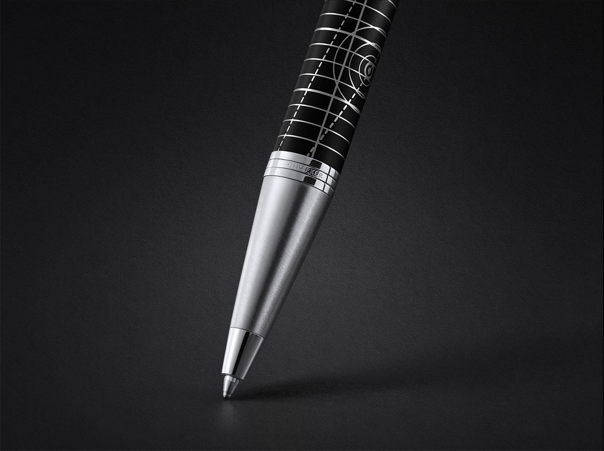 Zbliżenie na końcówkę długopisu Parker z metalową sekcją i czarnym korpusem z geometrycznym wzorem, na ciemnym tle.