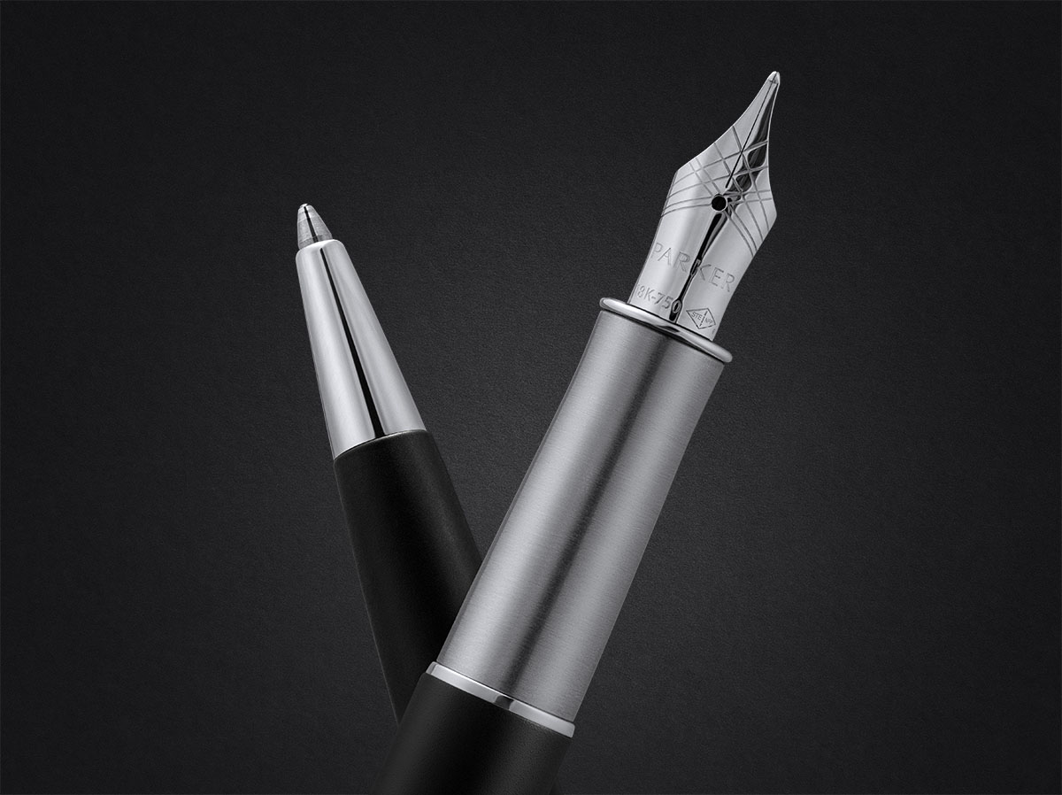 Zbliżenie na pióro wieczne i długopis Parker Sonnet w metalicznym wykończeniu na czarnym tle.